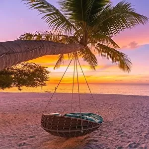 Tropical sunset beach background as summer landscape panorama with beach swing hammock and white sand and calm sea beach banner. Perfect beach scene