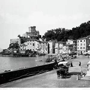 A carriage and some pedestrians on the seafront of San Terenzo, in the province of La Spezia