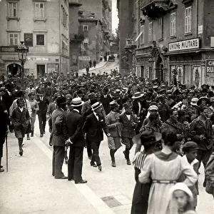 Italian soldiers walk along a road of Fiume followed by the population. The image was taken during the city occupation of Fiume by part of the Italian legionary troops, headed by Gabriele D'Annunzio