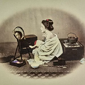 Portrait of a young japanese woman putting on her make-up