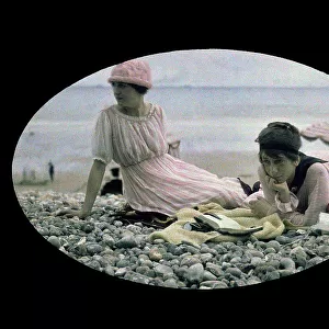 Two women sitting on a beach
