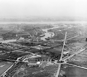 <b class=qtipBold><figcaption>Birkenhead in 1920 EPW004029</figcaption></b><br>BIRKENHEAD, Merseyside, August 1920. Aerial view. Prominent in the foreground are Queens Buildings with St James Church on its roundabout and Corporation Street. On the West Float of Wallasey Pool two Graving docks can be seen (beneath the aircraft wing) adjacent to Brassey's Canada Iron Works (where materials and rolling stock for Canada's Grand Trunk Railway were manufactured in the 1850s and 1860s) and the huge flour mills (including Ocean Flour Mills), which in the 1920s were milling more grain than anywhere else in Europe. The East Float, Mersey and Liverpool's Three Graces can be made out in the distance. Aerofilms Collection (see Links).<br><em>© Historic England</em> Birkenhead in 1920 EPW004029