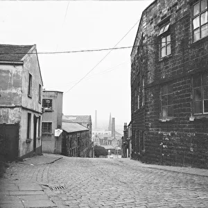 <b class=qtipBold><figcaption>Burnley DES01_01_0497</figcaption></b><br>Along Sandygate, Burnley, Lancashire, towards the town centre with the former Neptune Inn to the left foreground and Clock Tower Mill to the right foreground.. Photographed by Eileen Deste between 1966 and 1974.<br><em>© Historic England Archive</em> Burnley DES01_01_0497