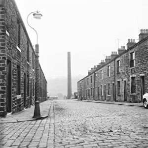 <b class=qtipBold><figcaption>Colne DES01_01_0546</figcaption></b><br>Looking south along Craven Street, Cotton Tree, Colne, Pendle, Lancashire, with the chimney of Swanfield Shed in the distance. Photographed by Eileen Deste between 1966 and 1974.<br><em>© Historic England Archive</em> Colne DES01_01_0546