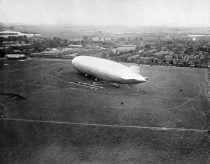<b class=qtipBold><figcaption>Graf Zeppelin EPW038817</figcaption></b><br>The Graf Zeppelin moored at Hanworth Aerodrome, London Air Park in July 1932. This was her third and final visit to the UK after a flight over London in 1930 and a 24-hour round-Britain passenger tour in August 1931. Once again she took a passenger tour around Britain in 24 hours before returning to Hanworth. Dr Hugo Eckener, the head of the Zeppelin passenger company, took personal charge of the Graf Zeppelin on several record breaking flights as well as using it as a public relations tool and an attraction drawing large crowds. From a copy negative. Aerofilms Collection (see Links).<br><em>© Historic England</em> Graf Zeppelin EPW038817