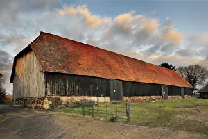 <b class=qtipBold><figcaption>Harmondsworth Great Barn N120001</figcaption></b><br>HARMONDSWORTH GREAT BARN, Greater London. Exterior view. Medieval timber framed barn built in 1426-7 by Winchester College. The Great Barn is one of the largest ever known to have been built in England, and one of the most complete and unaltered pre-Dissolution buildings in Britain. "Cathedral of Middlesex" Sir John Betjeman.<br><em>© Historic England</em> Harmondsworth Great Barn N120001