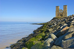 <b class=qtipBold><figcaption>Reculver Towers N100067</figcaption></b><br>RECULVER TOWERS AND ROMAN FORT, Kent. View of the twin towers with rocks of hard coastal defences in the foreground.<br><em>© Historic England</em> Reculver Towers N100067