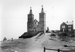<b class=qtipBold><figcaption>Reculver Towers OP00671</figcaption></b><br>RECULVER TOWERS, Kent. The remains of the west facade of St Mary's church stands on the cliff at Reculver. The original 7th century church was built on the site of an abandoned fort. In 1809 most of the church was pulled down, but the 12th century towers, known locally as the 'twin sisters', were retained as a navigational aid. When the original spires were destroyed by a storm c.1819, they were replaced with similar shaped, open structures containing weather vanes (they were removed c.1930). Photographed by W and Co. between 1890 - 1910.<br><em>© Historic England</em> Reculver Towers OP00671