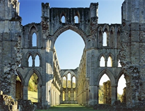 <b class=qtipBold><figcaption>Rievaulx Abbey J070050</figcaption></b><br>RIEVAULX ABBEY, North Yorkshire. The crossing and east end of the abbey church showing autumn colour on the trees beyond.<br><em>© Historic England</em> Rievaulx Abbey J070050