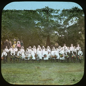 <b class=qtipBold><figcaption>Strawberry Fair TS00005</figcaption></b><br>Iffley, Oxford, Oxfordshire. A group of local children dressed in May Day costumes, posing for the camera before they start country dancing at the Strawberry Fair. Hand-tinted lantern slide photographed by Henry Taunt.<br><em>© Historic England Archive</em> Strawberry Fair TS00005