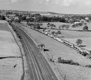 <b class=qtipBold><figcaption>Traffic jam EAR015159</figcaption></b><br>Preston-Lancaster Road, Lancashire. A traffic jam of cars and coaches, on the road, while the adjacent railway lines are empty. Aerial view by Aeropictorial. Aerofilms Collection. July 1951.<br><em>© Historic England</em> Traffic jam EAR015159