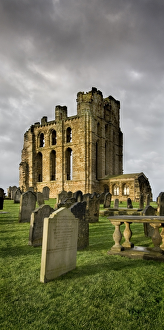 <b class=qtipBold><figcaption>Tynemouth Priory N080060</figcaption></b><br>TYNEMOUTH PRIORY, Tyne and Wear. The presbytery and chapel against a grey sky with grave stones in the foreground.<br><em>© Historic England</em> Tynemouth Priory N080060