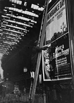 WW2 and WW2 Propaganda Posters: Woman pasting a billboard poster at Paddington station, 1943