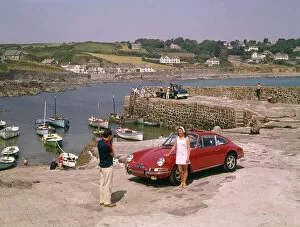 Resort Gallery: Couple with red car at Coverack, Cornwall