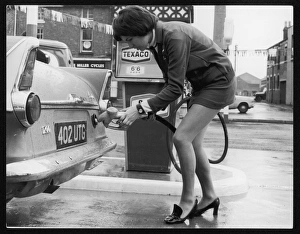 <b class=qtipBold><figcaption>Refuelling in a Mini</figcaption></b><br>The modern female petrol pump operator, refuelling a car in her mini skirt.<br><em>© Mary Evans Picture Library 2015 - https://copyrighthub.org/s0/hub1/creation/maryevans/MaryEvansPictureID/10083879</em> Refuelling in a Mini