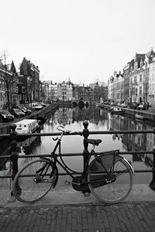 Railing Collection: Black and white image of an old bicycle by the Singel canal, Amsterdam