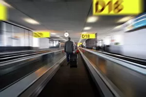 Stepping Collection: Businessman with luggage on travelator at Schiphol airport, Amsterdam, Netherlands