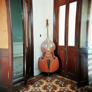 West Indian Gallery: Double bass propped against a wall, Cienfuegos, Cuba, West Indies, Central America