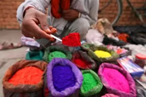 Nepalese Gallery: A dye trader offers his brightly coloured wares in a roadside stall in Kathmandu
