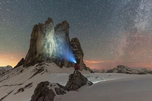 South Tyrol Collection: Hiker with head torch views the Tre Cime di Lavaredo on a starry night with the Milky Way