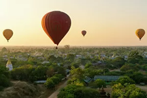Tourist Attractions Gallery: Hot-air balloons at sunrise over village near Bagan (Pagan), Myanmar (Burma), Asia