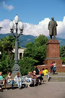 Crimea Collection: People sitting on benches near a statue of Lenin in Yalta
