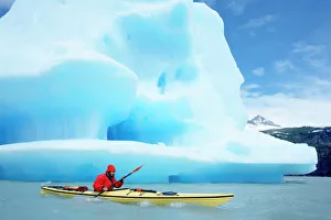 Person kayaking near floating icebergs, Lago Gray (Lake Gray), Torres del Paine National Park Person kayaking near floating icebergs, Lago Gray (Lake Gray), Torres del Paine National Park