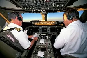 Seated Collection: Pilots on flight deck of Jumbo Boeing 747 of Air New Zealand with sunrise ahead
