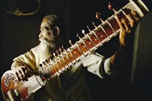 Seated Collection: Portrait of an elderly man playing the sitar