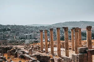 Tourist Attractions Collection: The ruins of a Roman temple, with the modern city of Jerash in the background, Jerash, Jordan