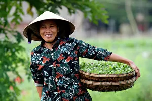 Adults Collection: Smiling Vietnamese woman wearing the traditional palm leaf conical hat, Hoi An, Vietnam