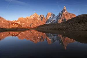 Tourist Attractions Collection: The Baita Segantini and the Pale di San Martino perfectly reflecting into a small lake at sunset