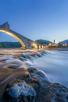 Tourist Attractions Collection: Europe, Italy, Emilia Romagna: Bobbio, falls on the Trebbia river and the medieval town at twilight