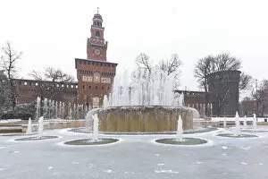 Tourist Attractions Gallery: A iced fountain and Sforzesco Castle after a snowfall. Milan, Lombardy, Northern Italy
