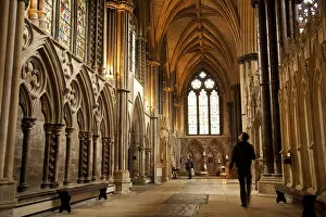 Lincoln, England. A visitor gazes at the medieval stained glass in Lincoln cathedral