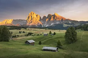 Tourist Attractions Collection: Lush green meadows and some old cabins create the classic alpine landscape at the Alpe di Siusi