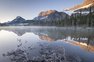 Morning mist burns off the still reflective waters of Bow Lake in the Canadian Rockies Morning mist burns off the still reflective waters of Bow Lake in the Canadian Rockies
