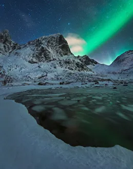 Northern lights over a partly frozen fjord during winter in the Lofoten islands, Norway Northern lights over a partly frozen fjord during winter in the Lofoten islands, Norway