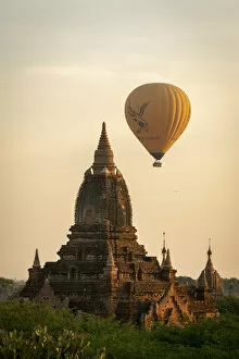 Pagoda Collection: Pagoda and hot air balloon at sunrise, Bagan, Myanmar
