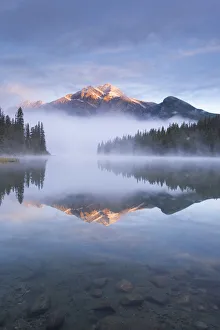 Pyramid Mountain in the Canadian Rockies surrounded by mist and reflected in Pyramid Lake Pyramid Mountain in the Canadian Rockies surrounded by mist and reflected in Pyramid Lake