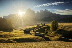 Tourist Attractions Collection: Some typical cabins in the meadows of the Alpe di Siusi (Seiser Alm) during an early autumn sunrise