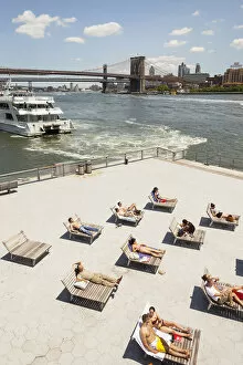 Enjoying Collection: People sunbathing beside East River, Brooklyn Bridge and South Street Seaport, Manhattan