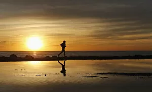 Leisure Time Collection: A man jogs during a sunset along the coast in Valparaiso city