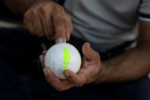 A Pakistani man living in Greece wraps a tennis ball in electrical tape before a