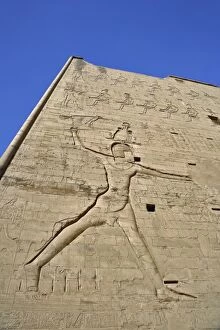 Temple Of Horus Collection: Giant figures and hieroglyphs on pylons of main entrance to Temple of Horus, at Edfu