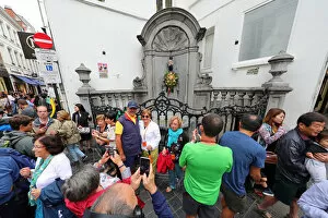 Crowds of tourists at the Manneken Pis, statue of a boy peeing into a fountain, Brussels