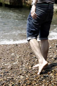 Man wearing striped T shirt on holiday at the seaside on the beach