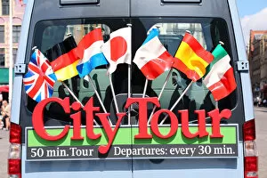 Sign with international flags on a City Tour sightseeing bus, Bruges, Belgium