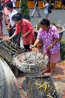 Women burning incense at Wat Phra Singh Temple in Chiang Mai, Thailand