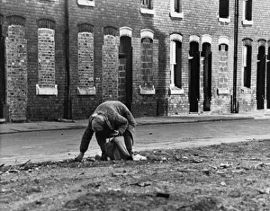 Old Woman sifting through roadside rubbish - Manchester 1973